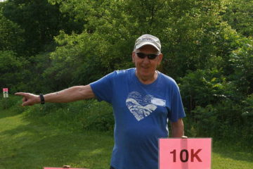 A volunteer points participants in the right direction during a trail run